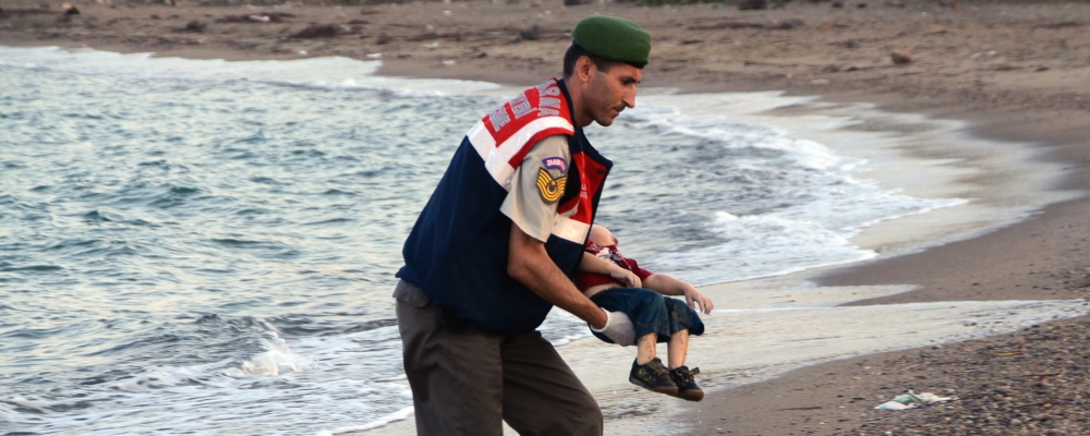 A Turkish paramilitary police officer carries the body of 3-year-old Aylan Kurdi, found washed ashore near the Turkish resort of Bodrum early Wednesday. The boats carrying the boy's family to the Greek island of Kos capsized. His 5-year-old brother and mother also lost their lives.